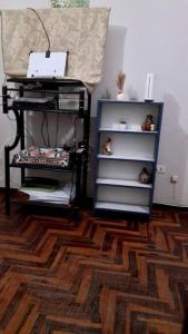 een kamer met een boekenplank en een tafel met een laptop bij Departamento vintage in Huancayo