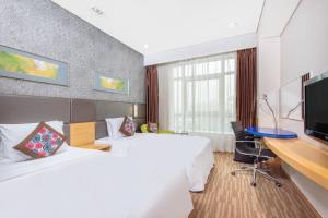 Habitación de hotel con 2 camas y escritorio en Holiday Inn Express Beijing Dongzhimen, an IHG Hotel en Pekín