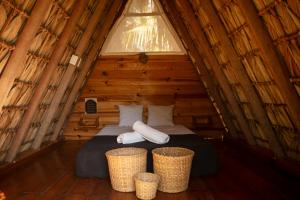 um quarto com uma cama num chalé de madeira em Porã Chacahua em Guayabas