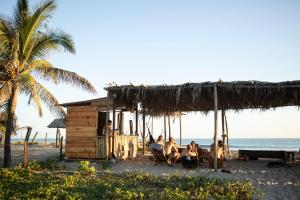 a group of people sitting in a hut on the beach at Porã Chacahua in Guayabas