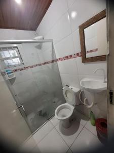 ein Bad mit einer Dusche, einem WC und einem Waschbecken in der Unterkunft Casa em Ilha Comprida (Temporada) - Monte Carlo in Ilha Comprida