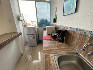 Playa Malecón, suites y Apart’s في مانتا: مطبخ مع مغسلة وثلاجة