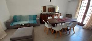 sala de estar con mesa, sillas y espejo en Chauvin House en Mar del Plata