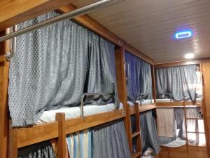 Kailasha - Hostel Cum PG في مومباي: سريرين بطابقين في غرفة مع ستائر