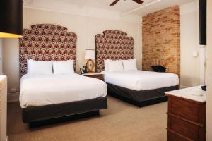 a hotel room with two beds and a brick wall at Hotel Colorado in Glenwood Springs