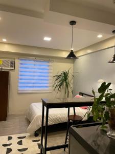 um quarto com uma cama, uma mesa e uma janela em Condo in Bacolod AMAIA steps em Bacolod