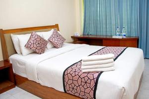 una camera da letto con un grande letto bianco con cuscini di Coral Reef Cox's Bazar a Cox's Bazar