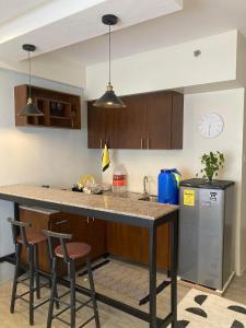 cocina con encimera con 2 taburetes y fregadero en Condo in Bacolod AMAIA steps, en Bacolod