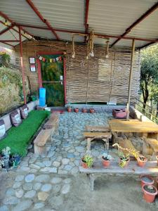 a patio with benches and potted plants and a table at Traveller Hive Kasar Devi in Almora +55 photos