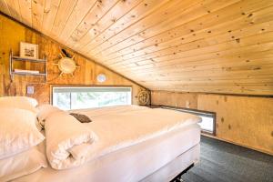 Cama en habitación con techo de madera en Serene Seldovia Cabin en Seldovia