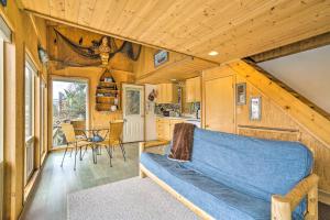 una sala de estar con un sofá azul en una casa pequeña en Serene Seldovia Cabin, en Seldovia