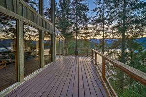a wooden deck with a view of the mountains at Swanhouse. Waterfront home. in Seldovia