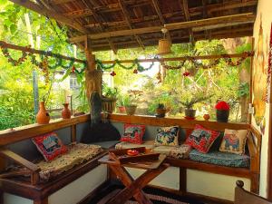 a porch with couches and a table and some plants at Mamisa Café, Home stay in Habarana