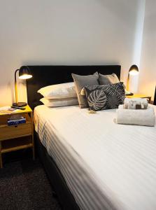 a bedroom with a large white bed with pillows at Manjimup Hotel in Manjimup