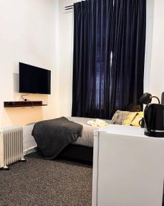 a bedroom with a bed and a window with a television at Manjimup Hotel in Manjimup