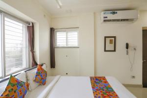 1 dormitorio con cama y ventana en FabHotel HRG Destiny, en Nagpur