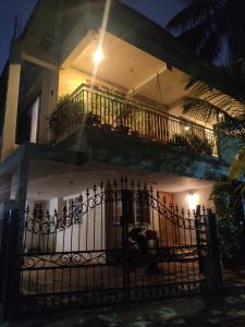 a house with a gate and a balcony at night at Laasya Vilaasa in Mangalore