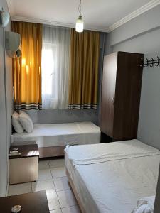 a hotel room with two beds and a window at NEZİH SUİTS OTEL in Antalya