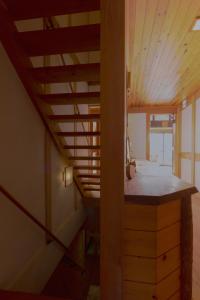 a staircase in a room with a wooden ceiling at Woody Island in Hakuba
