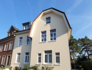 uma casa branca com um telhado de gambrel em "Zur Erholung" in Jugendstilvilla Sonnenschein em Stolberg