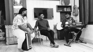 un grupo de tres personas sentadas en una habitación en KyGo Hostels en Hyderabad