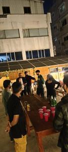海得拉巴的住宿－KyGo Hostels，一群人站在木桌旁
