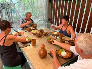 a group of people sitting around a table eating food at Akein Jungle Resort - Sigiriya in Sigiriya