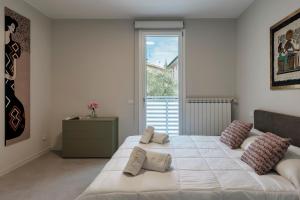 Un dormitorio con una gran cama blanca y una ventana en MALVEZZi Apartments, en Desenzano del Garda