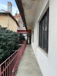 a walkway next to a building with a fence at SbOldTown by Holztreppe in Braşov