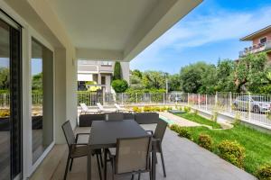 patio con mesa y sillas en el balcón en MALVEZZi Apartments, en Desenzano del Garda