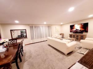 a living room with white furniture and a table at Spacious Buffalo Niagara Falls Apt, Close to Buffalo Airport in Depew