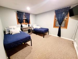 a bedroom with two beds and a desk and window at Spacious Buffalo Niagara Falls Apt, Close to Buffalo Airport in Depew