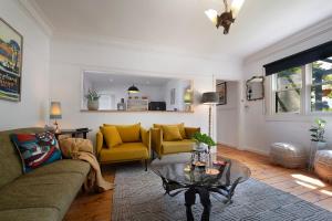 a living room with a couch and a table at Sausalito- captivating 1950s retro residence in Daylesford