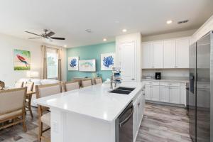 une cuisine avec des placards blancs et une salle à manger dans l'établissement 8 Minutes to Disney! Spacious Family Home in Margaritaville Resort in Kissimmee!, à Orlando