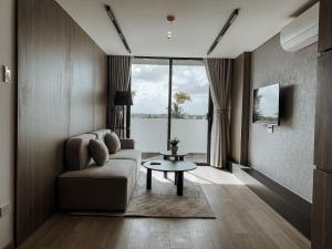 a living room with a couch and a table at Căn Hộ Ngoại Ô ( DANANG GOLFTEL & APARTMENTS ) in Hà Quảng (4)