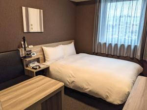 Postel nebo postele na pokoji v ubytování Hotel Route-Inn Chiba Hamano -Tokyowangando-