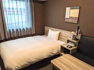 Postel nebo postele na pokoji v ubytování Hotel Route-Inn Chiba Hamano -Tokyowangando-