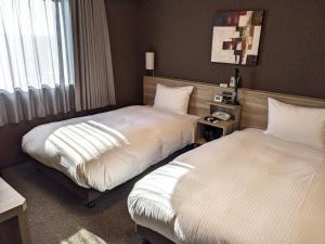 Postel nebo postele na pokoji v ubytování Hotel Route-Inn Chiba Hamano -Tokyowangando-