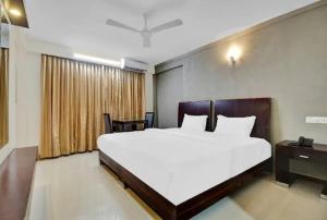 Un dormitorio con una gran cama blanca y una ventana en AEC Travel and Leisure Solution Pvt Ltd, en Alleppey