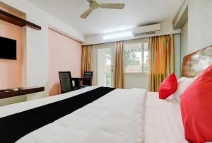 sypialnia z dużym białym łóżkiem z czerwonymi poduszkami w obiekcie AEC Travel and Leisure Solution Pvt Ltd w mieście Alappuzha