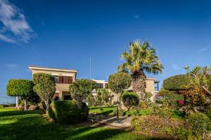 una casa con una palmera y un jardín en Mountain/sea view 6 Bedroom Villa in Chirokitia, en Lárnaca