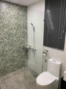 a bathroom with a toilet and a glass shower at Vivacity Megamall Jazz Suite Kuching 8pax 3BR #Joyoustayz1 in Kuching