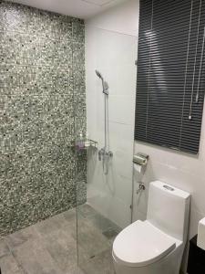 a bathroom with a toilet and a glass shower at Vivacity Megamall Jazz Suite Kuching 8pax 3BR #Joyoustayz in Kuching
