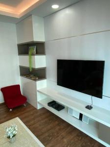 a living room with a tv and a red chair at Vivacity Megamall Jazz Suite Kuching 8pax 3BR #Joyoustayz in Kuching