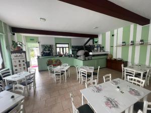 a restaurant with tables and chairs and a kitchen at Il Gatto e La Volpe in Avigliana