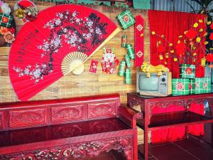 Habitación con sombrillas rojas y TV en la pared. en SenHomestay 