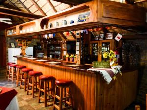un bar con una fila de taburetes en un restaurante en La Frans Guesthouse en Pretoria