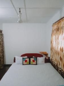 a bedroom with a bed with a white bedspread at Villa Samudra Hikkaduwa in Hikkaduwa