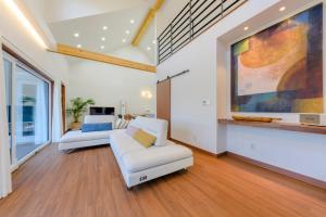 a living room with a white couch and a painting at Tov & Kara in Jeju