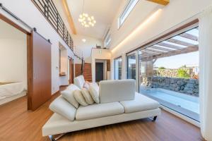 a living room with a white couch and a laptop at Tov & Kara in Jeju +79 photos